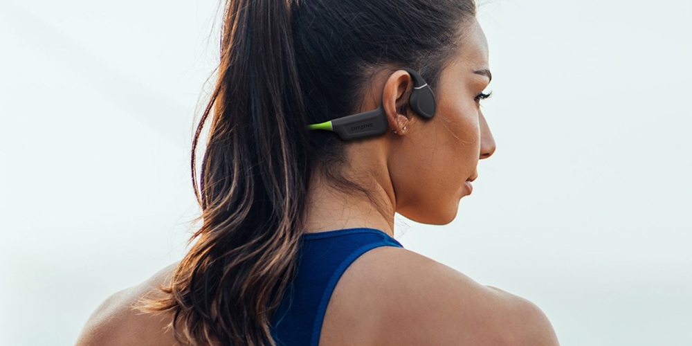 Słuchawki bezprzewodowe Creative Outlier Free Plus Bluetooth 5.3 szaro-zielone kobieta ze słuchawkami na uszach